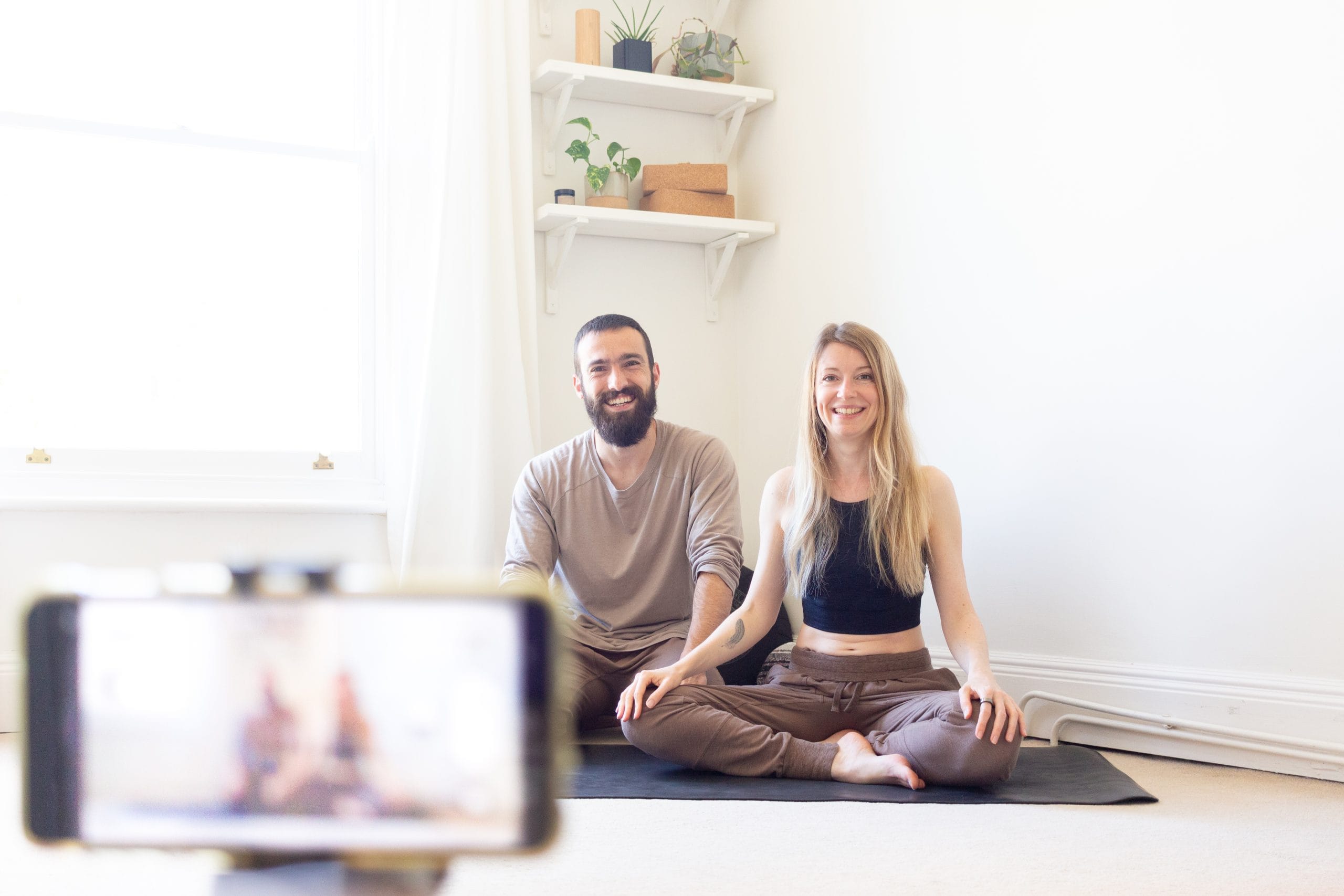 Deux professeurs de yoga assis sur leur tapis, prêt à enseigner un cours de Strala Yoga gratuit