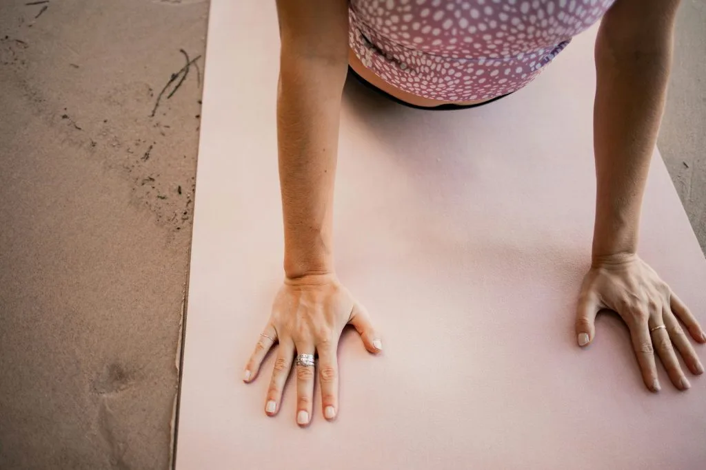 Jeune femme sur son tapis en posture du cobra, profitant d'une séance de yoga pour dormir et se relaxer avant le coucher