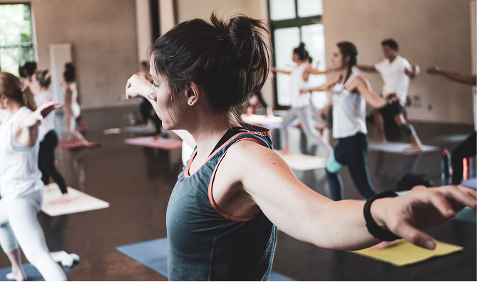 Une pratiquante de yoga en posture du guerrier 2